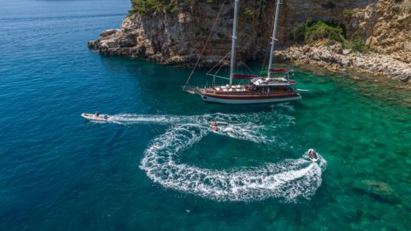 5 kabinli Gulet Adriatic Holiday, berrak turkuaz denizde heyecan verici su sporlarının tadını çıkaran insanlarla birlikt