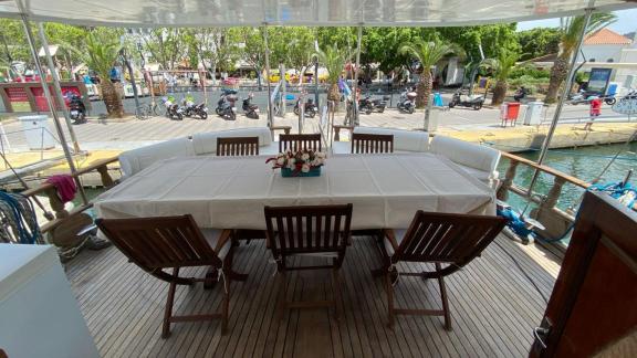 Крытая обеденная зона на гулете Be Happy в гавани, идеально подходит для приема пищи на свежем воздухе.