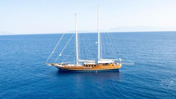 A majestic gulet named Bedia Sultan sails calmly in the wide, blue sea off Bodrum.