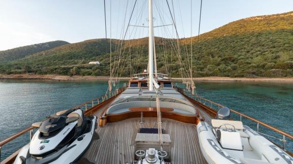 View of the deck of the gulet Bedia Sultan from Bodrum, equipped with a jet ski and a dinghy, at anchor in a picturesque