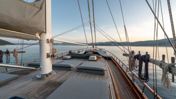 Das Sonnendeck der Gulet Bedia Sultan aus Bodrum, ausgestattet mit Liegeflächen und umgeben von einer idyllischen Küsten