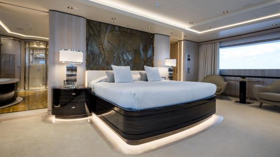 Bedroom on the Opari yacht with a large bed, stylish lighting, and sea views.