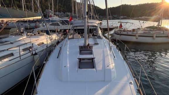 The foredeck of Triton 89 sailing yacht docked at the pier, surrounded by other boats.