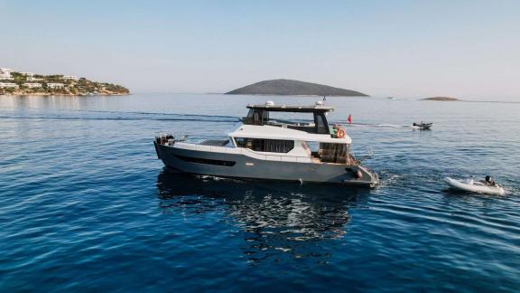 Ein Beiboot begleitet die Yacht Berre Lal vor Bodrum auf dem Wasser.