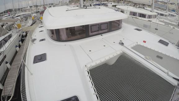 Upper deck of the Aymeline catamaran in port, offering a spacious area for sunbathing and relaxation.