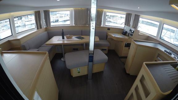 The bright and spacious saloon of the Aymeline catamaran features comfortable seating and a dining area.