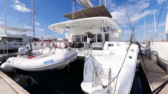 Der Katamaran Saelma Lagoon 450 liegt im Hafen mit angelegtem Beiboot, bereit für Ihr Abenteuer in Kroatien.