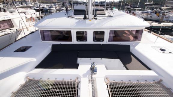 The modern foredeck of the Saelma Lagoon 450 with comfortable seating areas and nets in the marina.