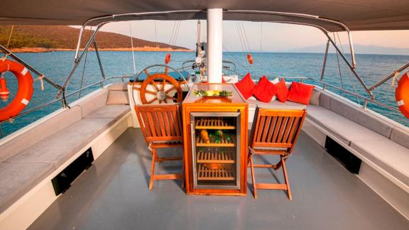 Cockpit of the luxurious Gulet Bodrum Queen in Bodrum, Turkey, with seating area and steering wheel.