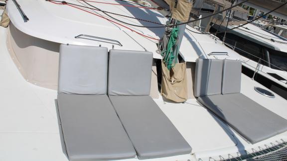 Two grey sun loungers on the front deck of Catamaran Ayda1.