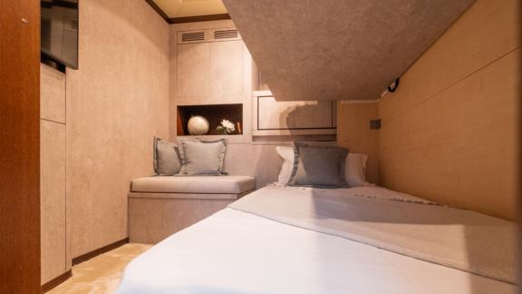 This single cabin on motor yacht Five Stars features a comfortable bed and modern decor.