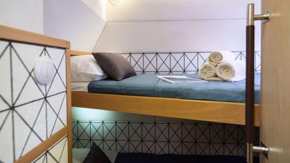 The bunk cabin of Ace of Hearts in Athens features two-level beds, towels and a compact layout.
