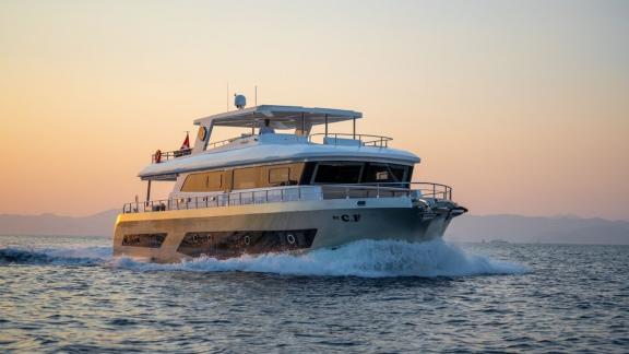 By CF trawler yacht glides peacefully through the sea at sunset near Fethiye.