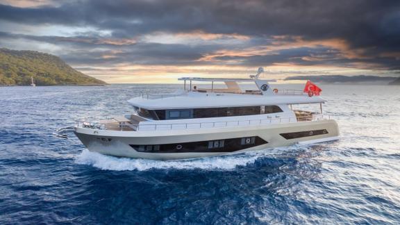 By CF trawler yacht is cruising off the coast of Fethiye at sunset.