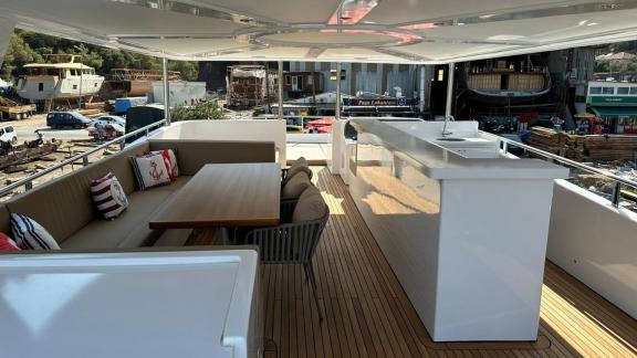 The upper deck of By CF trawler features cushioned seating and a sleek bar counter.