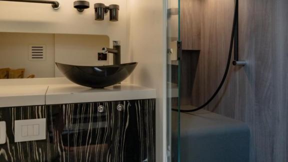 The private bathroom of Vibe in Ibiza features a modern sink unit and a glass shower area.