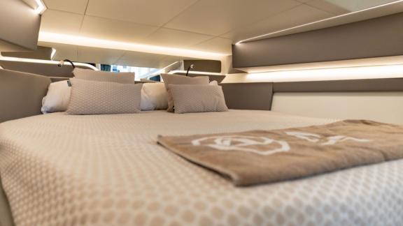 The modern cabin of Vibe in Ibiza features a spacious bed designed for a comfortable yacht holiday.