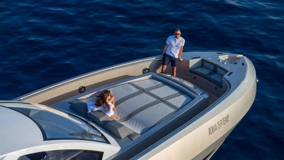 A couple enjoys the sun on the front deck while cruising off the coast of Mallorca.