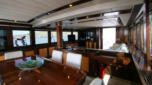 High-end furnished salon with dining area and sea view on a yacht in Bodrum.