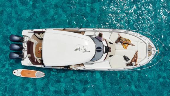 Gäste genießen den Blick auf das türkisfarbene Meer vom Deck der Motoryacht Carmencita la Grande.