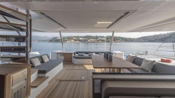 Spacious seating and dining area with sea view on the aft deck of the 7th Heaven catamaran in Athens.