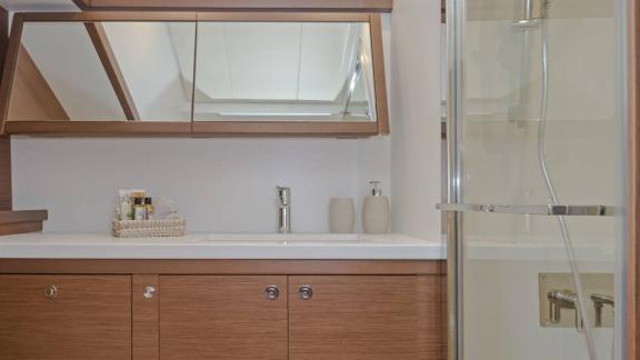 The bathroom of Ace of Hearts in Athens features a sink cabinet, mirror and glass shower cabin.