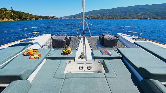 The foredeck of Ace of Hearts in Athens features cushioned sunbeds and an open sea view.