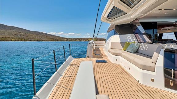 Cushioned bench on the sunlit side deck while anchored off Lavrion.