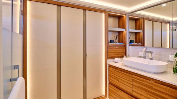 Bathroom features a large mirror, open shelves and stylish wooden finishes.