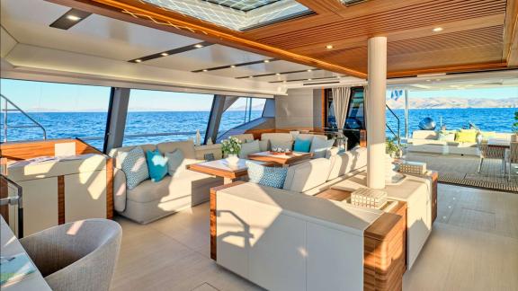 Spacious lounge with soft seating and full-length windows facing the open sea.