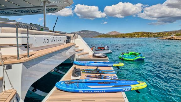 Paddle boards and inflatable toys are ready by the stern near Lavrion coast.