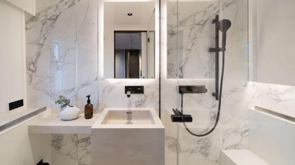 Modern marble-detailed bathroom aboard the Adara Next catamaran, departing from Athens.