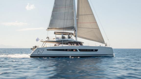 Yunanistan'da mavi denizde tam yelkenle lüks Aether (Fountaine Pajot) katamaranı.