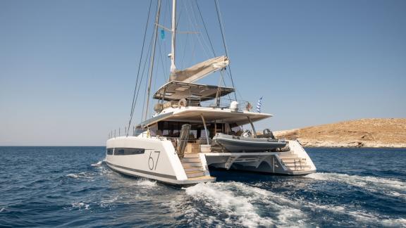 Yunanistan kıyılarında berrak, mavi sularda yelken açmış lüks Aether (Fountaine Pajot) katamaranı.