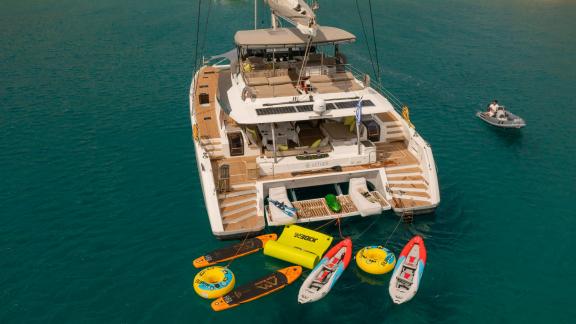 Turkuaz sularla çevrili, su sporları ekipmanına sahip lüks Aether (Fountaine Pajot) katamaranı.