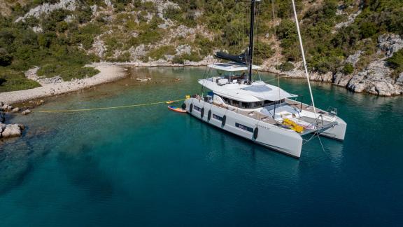 Agenda 55 catamaran is anchored in turquoise waters near Kastela during a peaceful catamaran holiday at sea.