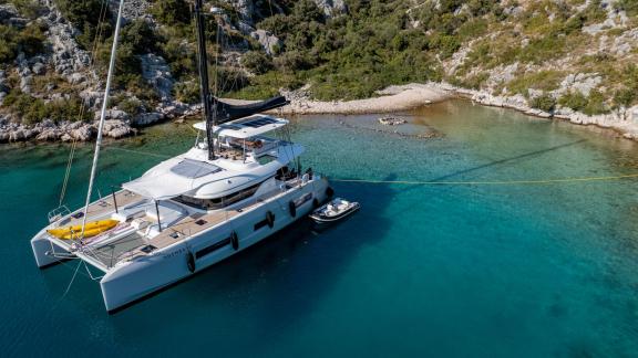 Agenda 55 catamaran is anchored in clear turquoise waters near Kastela during a luxury sailing holiday.