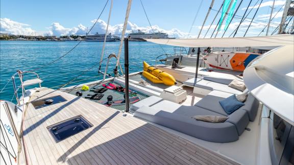 Agenda 55 catamaran features sunbeds and water toys on the spacious front deck overlooking the sea.