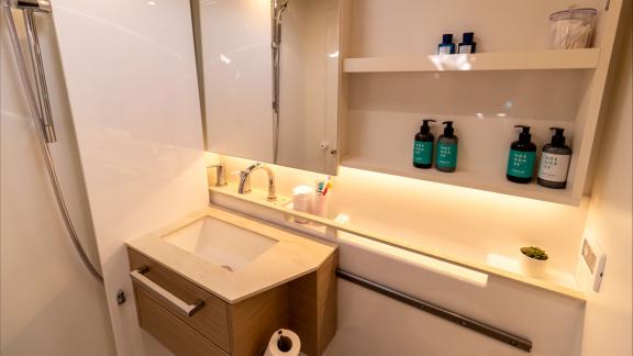 Agenda 55 catamaran features a stylish bathroom sink area with illuminated shelves and modern details onboard.