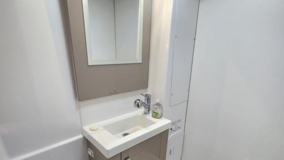 Современная ванная комната катамарана Astrea 42 с стильной раковиной и зеркалом предлагает просторное пространство.