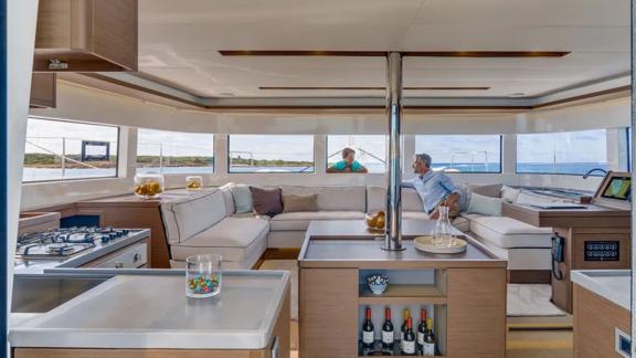 A boy and his father talk in the saloon of the catamaran Alchera.