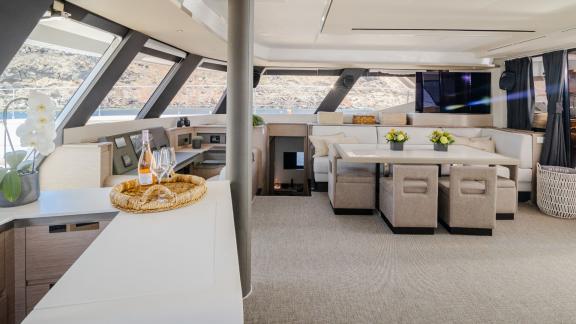 Stylish interior with dining area and panoramic windows on a catamaran.