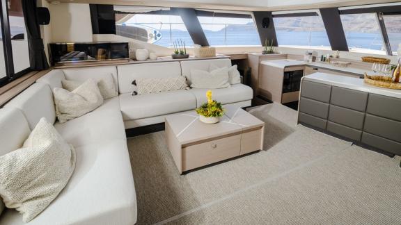 Cozy living area with corner sofa and panoramic windows on a catamaran.