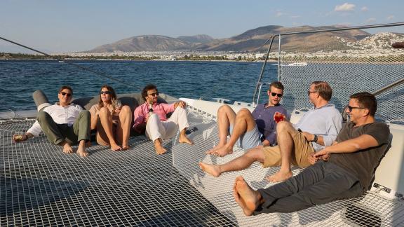 Friends enjoying a relaxing day tour aboard catamaran Alimos in Athens.