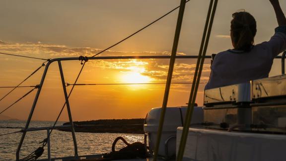Passenger enjoying sunset views on a coastal catamaran tour from Athens in Greece.