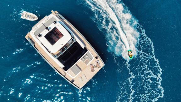 Aerial view of the Catamaran Alteya with a jet ski on open waters, suitable for up to 8 people.