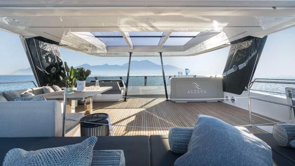 Spacious lounge area on the Catamaran Alteya, offering panoramic views of the sea and mountains, perfect for relaxation.