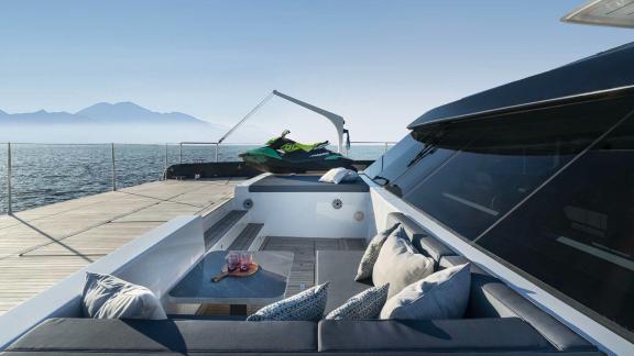 Stylish lounge area on the Catamaran Alteya, featuring a jet ski on deck and panoramic views of the sea and mountains.