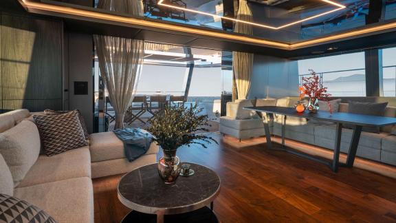 Luxurious salon on the Catamaran Alteya featuring modern furnishings, soft sofas, and access to the outdoor terrace.