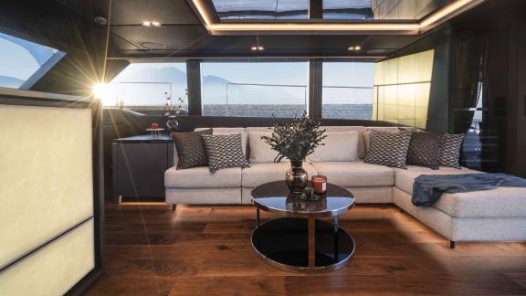 Stylishly furnished salon on the Catamaran Alteya, illuminated by the warm light of the sunset, with sea views.